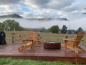two chairs and a fire pit on a deck with a view at Ongarue Valley Retreat in Ongarue +11 photos