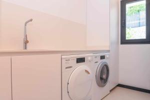 a washing machine in a white room with a window at Bonita stay B Sky Piscina caliente, vistas, wifi in Jávea