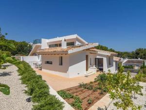 a large white house with a large yard at Bonita stay B Sky Piscina caliente, vistas, wifi in Jávea