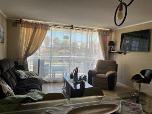 a living room with a couch and a chair and a window at Disfruta en Familia! in Algarrobo