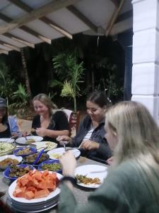 a group of women sitting at a table with food at Relax garden in Sigiriya
