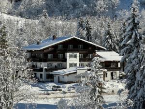 a house in the snow with snow covered trees at Pension Baranekhof - closest to the Kitzsteinhorn Ski Resort in Kaprun
