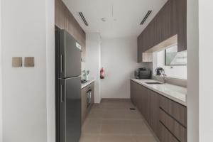 a kitchen with a sink and a refrigerator at F1 Yas Luxury 1BR Golf&Water View w tkt discount in Abu Dhabi