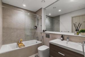 a bathroom with a tub and a toilet and a sink at F1 Yas Luxury 1BR Golf&Water View w tkt discount in Abu Dhabi