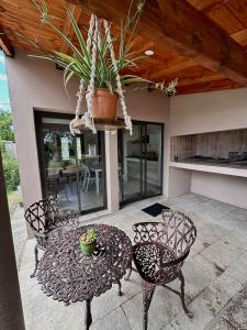 a patio with two chairs and a table with a potted plant at ALMAS CASAS de SIERRAS in San Lorenzo