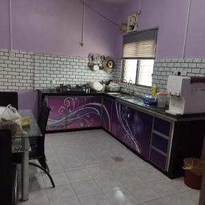 a kitchen with purple walls and a purple counter top at Mastermind Malay Semeling Homestay in Bedung