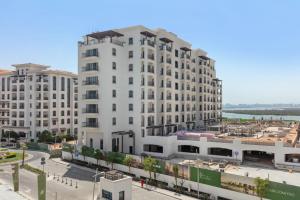 a large white building with a street in front of it at Luxury 1br Yas Island, Golf & Water Views!near F1 in Abu Dhabi