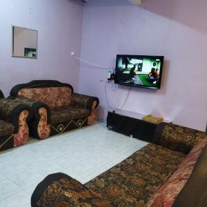 a living room with a couch and a tv at Mastermind Malay Semeling Homestay in Bedung