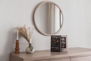 a table with a mirror and a book and a vase at F1 Yas Luxury 1BR Golf&Water View w tkt discount in Abu Dhabi +33 photos