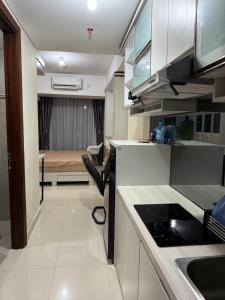 Una cocina con fregadero y una habitación con cama. en Pollux Superior 2 seaview by Superstay, en Batam Centre