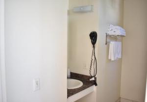 a bathroom with a sink and a phone on the wall at Valley Hotel in Rosemead +56 photos
