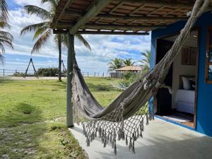 a hammock hanging from a house on the beach at Casa Sol e mar in Porto Seguro
