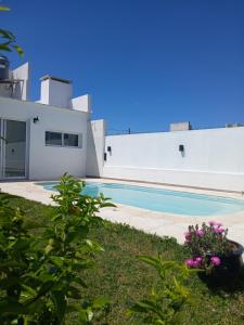 a white house with a swimming pool in front of it at Serena in Concepción del Uruguay