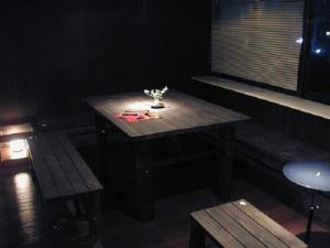 a table and benches in a dark room at International Guesthouse Azure Narita in Narita