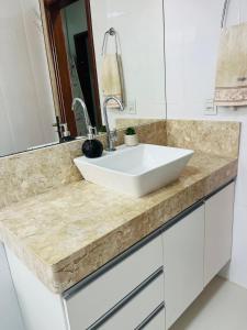 a bathroom counter with a white sink and a mirror at Jardim das Pérolas 101 in Belém