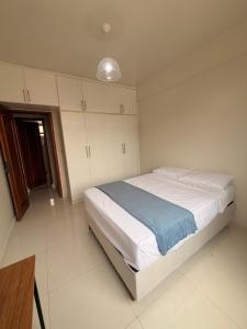 a bedroom with a large bed with white cabinets at Jardim das Pérolas 101 in Belém