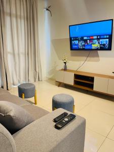 a living room with a couch and a flat screen tv at Jardim das Pérolas 101 in Belém