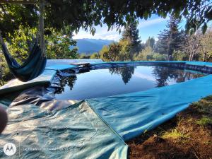 a swimming pool with a blue tarp around it at ChacraKremen in El Bolsón