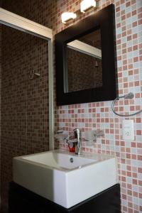 Un baño con un lavabo blanco y un espejo. en Casa de la Puesta del Sol, en Tequesquitengo