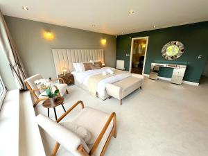 Un dormitorio con una cama, un sofá y una silla. en Luxury 8- bed Mansion in Prestigious Alderley Edge, en Alderley Edge 32 fotos más