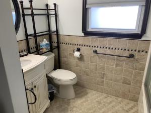 a bathroom with a toilet and a sink and a window at Beach Haven West Lagoon Front Property Pets Accepted With Wifi in Beach Haven West +13 photos