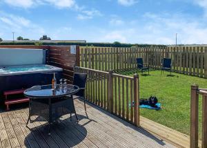 a patio with a table and a dog laying on the grass at Fairview Lodges in Hollym