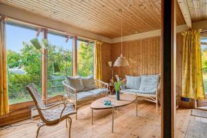 ein Wohnzimmer mit Stühlen und einem Tisch in der Unterkunft Older Holiday Home Near Bønnerup Strand in Glesborg