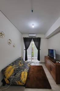 a living room with a bed and a television at Apartemen 2 Kamar Podomoro in Medan