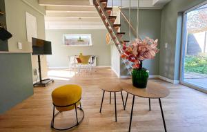 Una habitación con una mesa y sillas y un jarrón con flores. en Cozy Home In Bergen Aan Zee With Wifi, en Bergen aan Zee