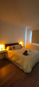 una camera da letto con un grande letto bianco con due luci di Tu departamento en Olavarría te espera! a Olavarría
