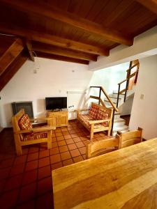 a living room with wooden furniture and a staircase at Pucon Antu I - De la Montaña in Esquel