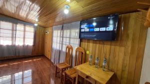 a room with a table and a tv on the wall at CABAÑAS RANCH OXaPAMP4 in Oxapampa