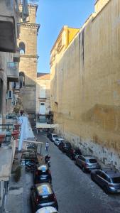 a group of cars parked on a street next to a wall at San Gregorio Suite&Rooms in Naples
