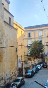 a street with cars parked in front of buildings at San Gregorio Suite&Rooms in Naples