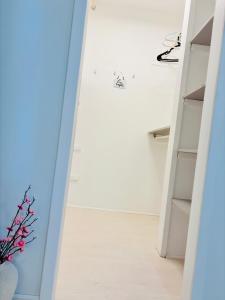 a hallway with white shelves and a vase of flowers at 210 Bertrand St in Winnipeg +53 photos