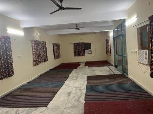 an empty room with carpets on the walls at Adichunchangiri Mahasamsthana Math in Naimishāranya