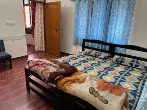 a bedroom with a bed in a room with blue curtains at Adichunchangiri Mahasamsthana Math in Naimishāranya