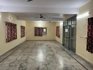 an empty room with a ceiling fan and paintings on the walls at Adichunchangiri Mahasamsthana Math in Naimishāranya