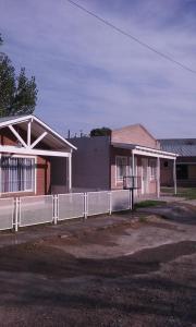 a building with a fence in front of it at El Sosiego in Trelew