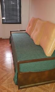 a bedroom with a bed with green sheets and pillows at El Sosiego in Trelew