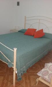 Un dormitorio con una cama con almohadas rojas. en El Sosiego en Trelew