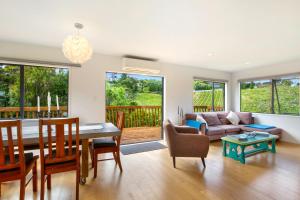 a living room with a table and a couch at Casita Vista Waiheke in Waiheke Island