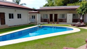 a swimming pool in a yard next to a house at Freedive Panglao Resort in Panglao Island