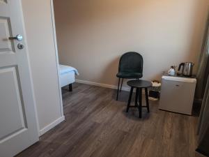 Una habitación con una silla y una mesa en una habitación. en Berlevåg Motell AS, en Berlevåg