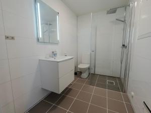 Un baño con inodoro, lavabo y ducha. en Berlevåg Motell AS, en Berlevåg