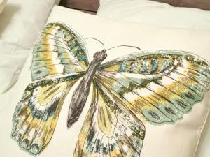 a drawing of a butterfly on a pillow at Gîte de charme à Thiel-sur-Acolin : terrasse, grand terrain, barbecue et équipements modernes - FR-1-489-338 in Thiel-sur-Acolin