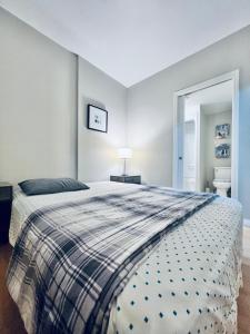 a bedroom with a bed with a plaid blanket at Peaceful, charming and cosy independent and private suite with kitchen and bathroom in desired north Glenmore - perfect for any stay in Kelowna