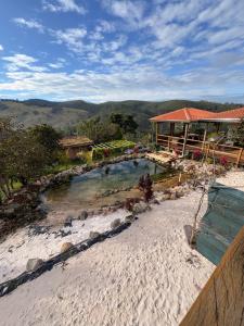 a resort with a swimming pool next to a river at Santuário Panacéia in Piracaia