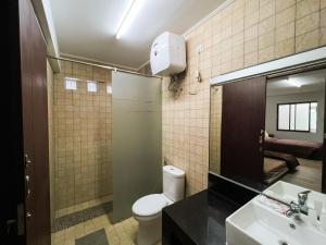 un bagno con un water, un lavandino e uno specchio di Oase Resort Bandung a Bongkor 1 Altre 12 foto