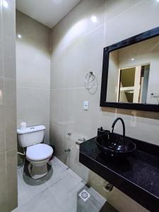 a bathroom with a toilet and a sink and a mirror at Amoras flat in Sao Jorge +26 photos